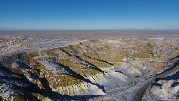 Geweldige luchtfoto van de zanderige bergen sneeuw-bekleding in West Kazakhstan, Mangyshlak schiereiland. Woestijn in de sneeuw. — Stockvideo