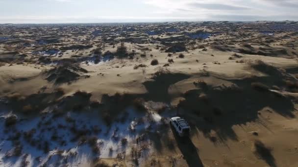 Havadan görünümü SUV kış aylarında karla kaplı çölde hareket. Batı Kazakistan, Mangışlak Yarımadası. — Stok video