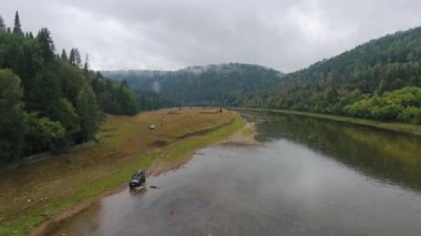 Araba ile nehir gidiyor. Dağ. Orman. Ural.