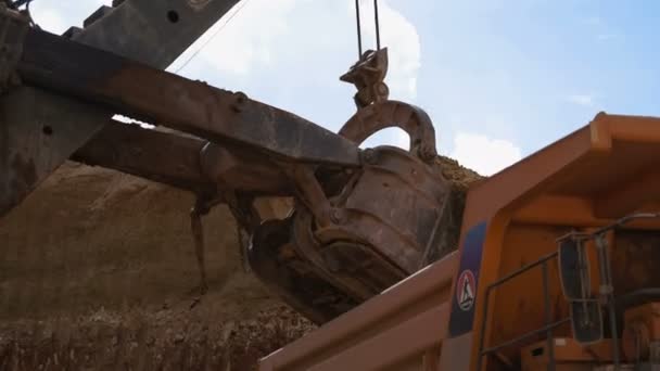덤프 트럭으로 로드 하는 광 석 굴 착 기 물통의 핸드헬드 촬영. — 비디오