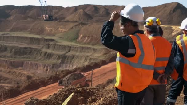 Panorama tiro de um grupo de trabalhadores em macacão ativamente falando a bordo de uma pedreira de bauxita . — Vídeo de Stock