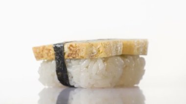 Beyaz arkaplanda izole edilmiş nigiri suşisinin üst görüntüsü.