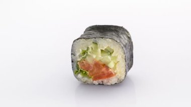 Beyaz arka planda somon ve salatalıklı Norveç usulü suşi rulosu..