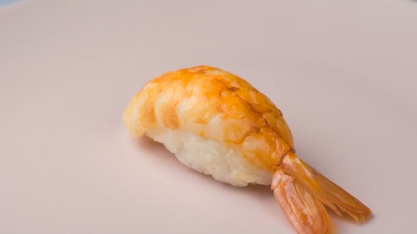 Shrimp nigiri sushi na wirującym różowym talerzu. — Wideo stockowe