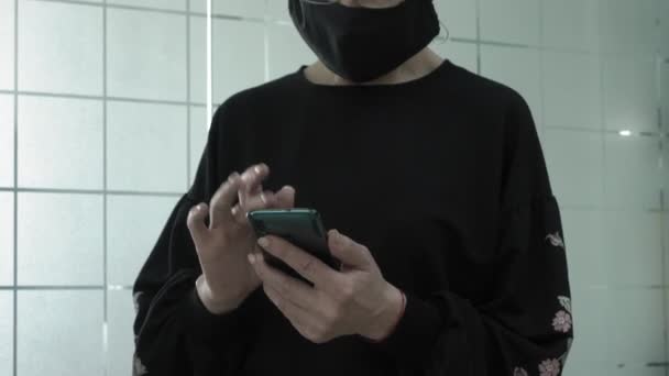 Kantoorwerk tijdens een pandemie COVID-19. Oudere vrouw in gesprek op smartphone in beschermende maskers in kantoor coridor. — Stockvideo