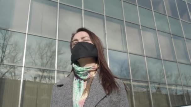 Retrato de mujer preocupada de pie en la calle con máscara protectora y el uso de teléfono inteligente. Jovencita ocupada leyendo noticias sobre coronavirus. Covid-19, pandemia, peligro . — Vídeo de stock