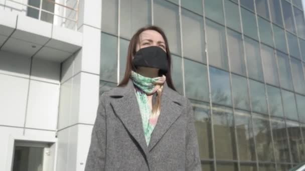 保護マスクで路上に立って、スマートフォンを使用している心配女性の肖像画。コロナウイルスについてのニュースを読んで忙しい若い女の子。Covid-19 、パンデミック、危険. — ストック動画