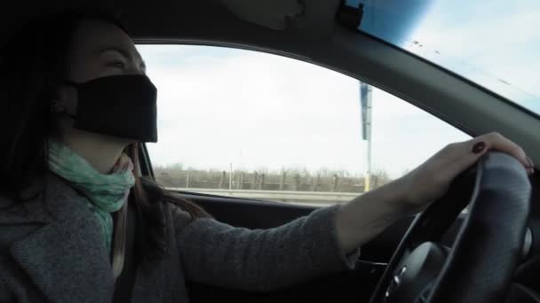 Mulher dirigindo usando uma máscara facial Covid-19 durante coronavírus — Vídeo de Stock
