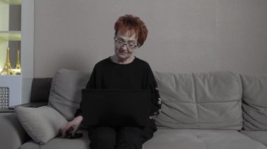 Üst düzey bir kadın ailesiyle Skype üzerinden bilgisayarda iletişim kuruyor. Dünya çapında küresel COVID-19 salgını.