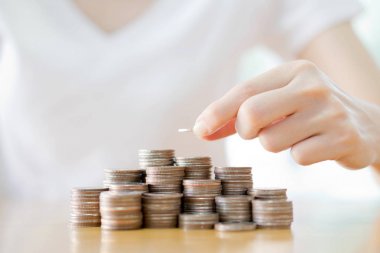 Kadın el yığın altın sikkeler üzerinde beyaz ba izole kapatmak