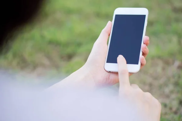 Çiftlik arka plan üzerinde bir cep telefonu kullanarak el closeup — Stok fotoğraf