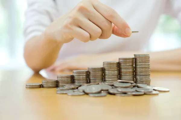 Woman put coins to stack of coins — Stock Photo, Image