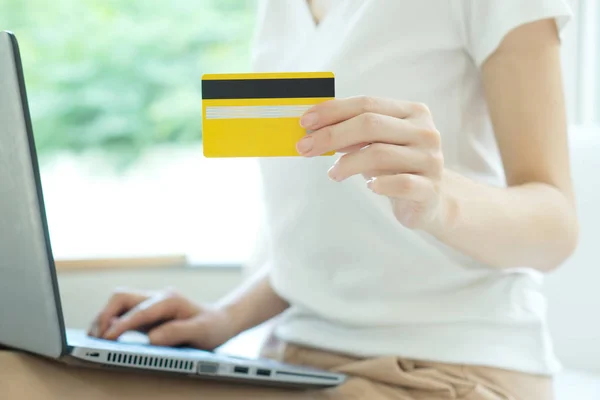 Ung vacker kvinna med laptop och kreditkort hemma — Stockfoto