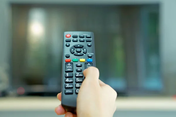 Watching TV and using remote controller — Stock Photo, Image