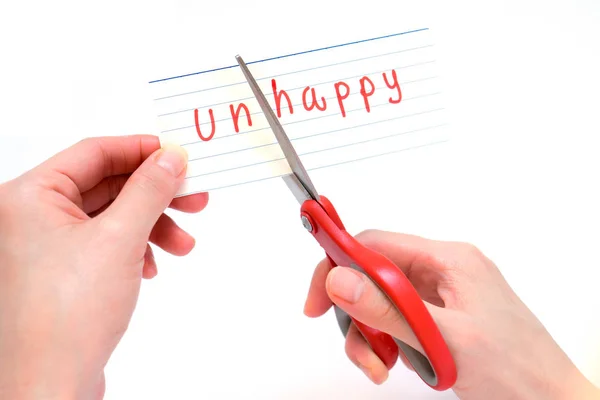 Vrouw met behulp van schaar te verwijderen het woord ongelukkig te lezen gelukkig c — Stockfoto