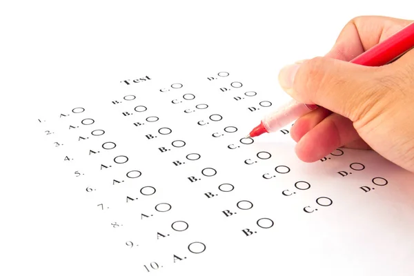 Mão sobre caneta vermelha escolhendo a lista de teste no exame — Fotografia de Stock