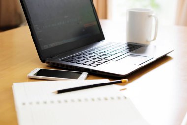 Modern dizüstü bilgisayar, cep telefonu, tablet, kahve fincanı ve defter