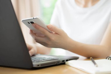 Bir cep telefonu holding eller kız. Boş olan dizüstü bilgisayar 