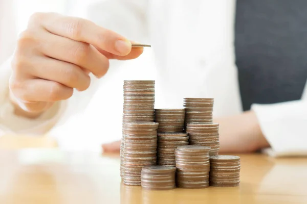 Empresaria poner monedas a pila de monedas —  Fotos de Stock