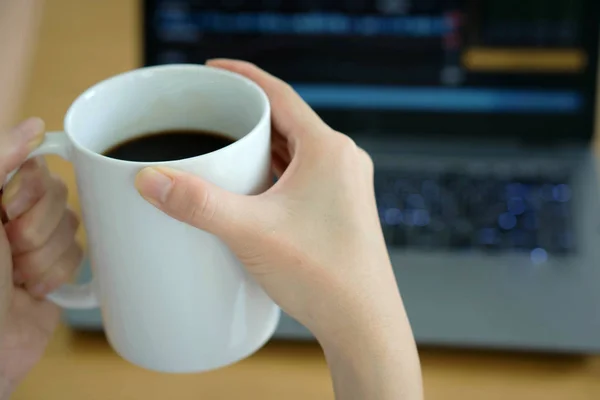 Pengusaha wanita muda minum kopi dan menggunakan laptop — Stok Foto