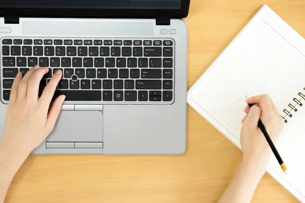 En kvinnor händer använder laptop med blank skärm och skriva i not — Stockfoto