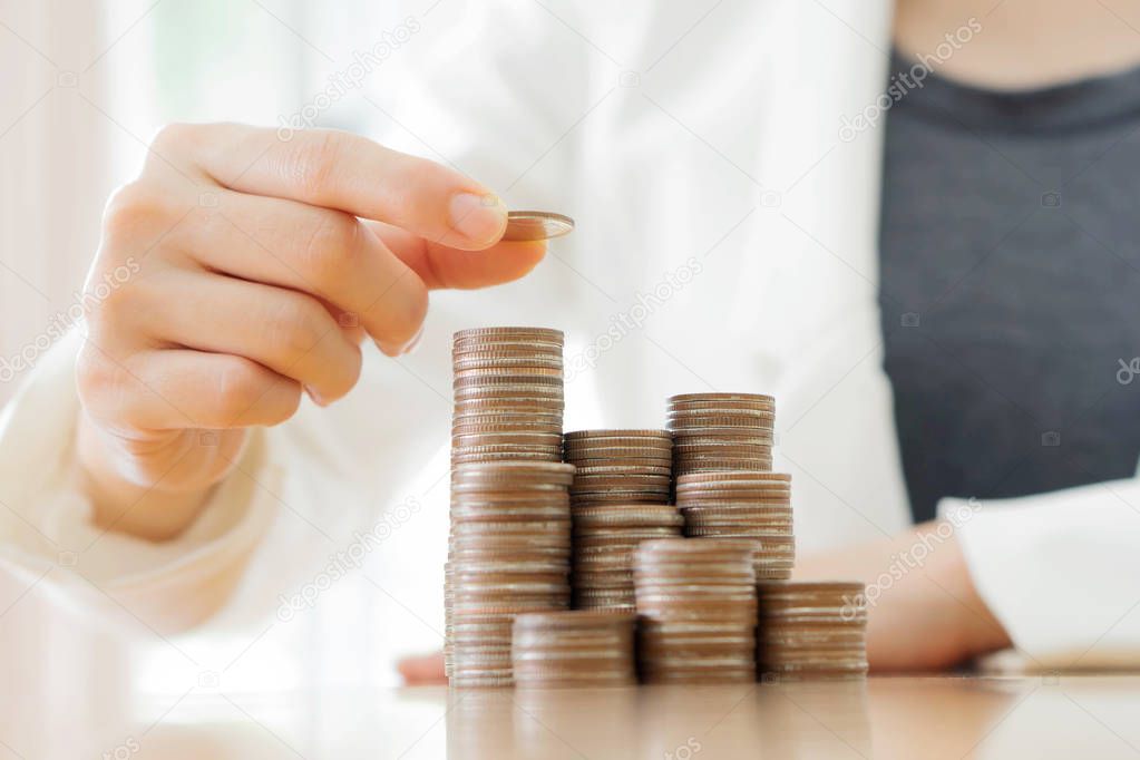 Businesswoman put coins to stack of coins