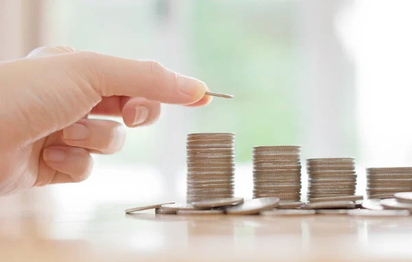 Woman put coins to stack of coins — Stock Photo, Image