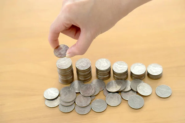Жінка поклала монети в стос монет — стокове фото