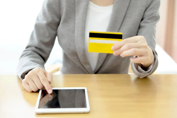 Close-up woman's hands holding a credit card and using tablet pc — Stock Photo, Image