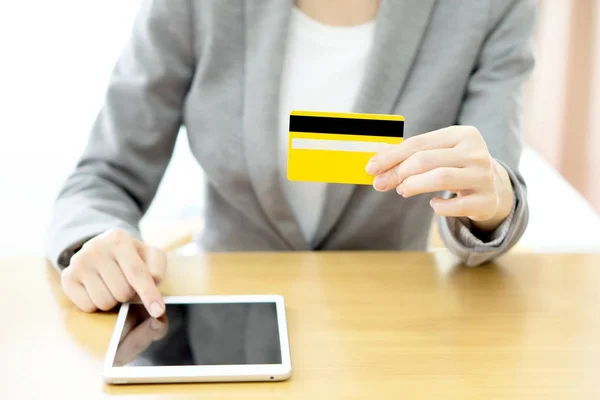 Close-up woman's hands holding a credit card and using tablet pc — Stock Photo, Image