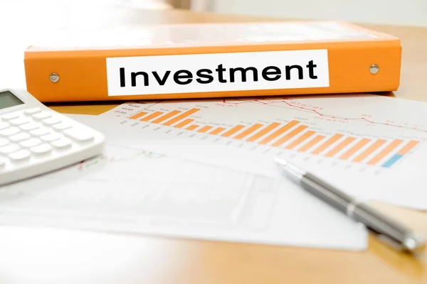 Orange binder investeringar på kontoret med miniräknare — Stockfoto