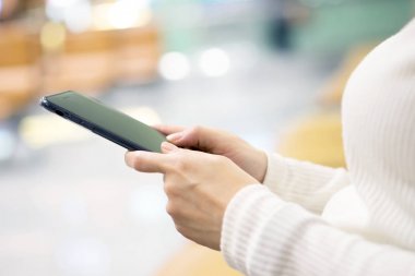 Akıllı telefon kullanan genç bir kadın. -