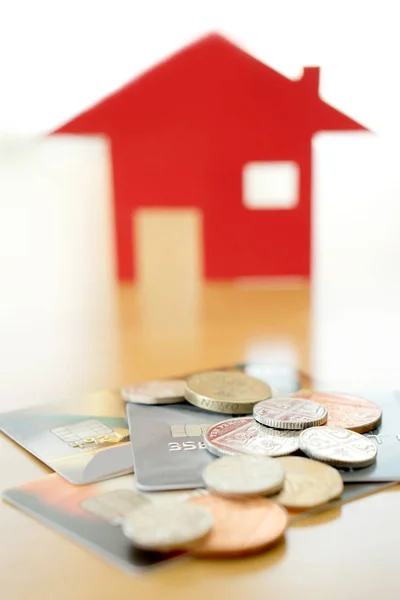 Інвестиції в нерухомість за кредитною карткою. Будинок і монети — стокове фото