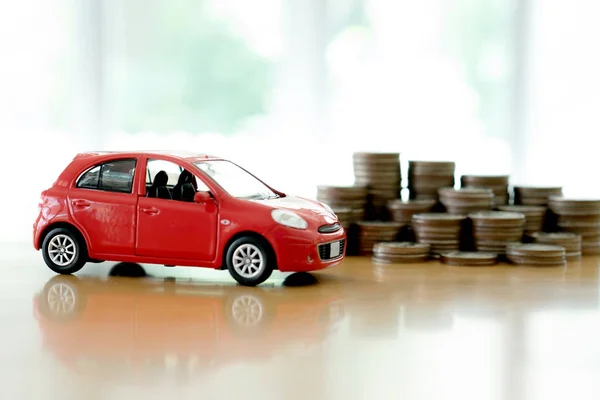 Montones de monedas de plata gigantes junto a un nuevo coche rojo —  Fotos de Stock