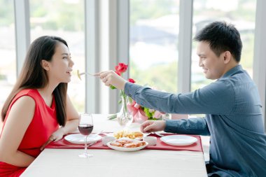 Mutlu adam ve kadın bir restoranda yemek yiyorlar, Sevgililer Günü 'nde..
