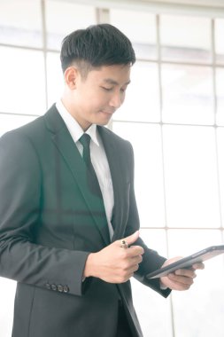 A businessman  analysis document  seen through glass in new offi