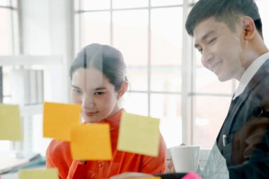 İş adamı ofiste genç bir kadınla beyin fırtınası yapıyor..