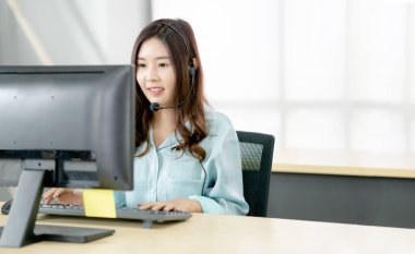 Şirin bir iş kadını müşterileriyle hesaplarının önünde konuşuyor.