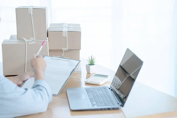 Başlangıçta küçük işletme girişimcisi KME, dizüstü bilgisayar ve teslimat kutusuyla çalışan Asyalı genç adam, çevrimiçi pazar