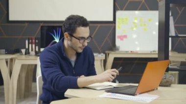 İşyerinde dizüstü kullanarak bardaklarda yaratıcı adam