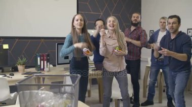 Grup arkadaşları kağıt çöp sepeti atar.