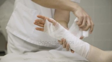Doktor alçı yastık hasta el koyar.