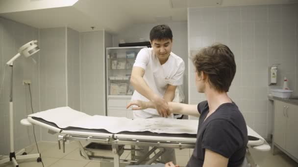 Doktor dává sádra pad na straně pacientů — Stock video