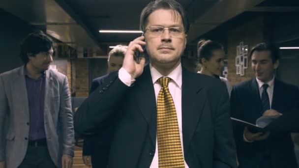 Uomo d'affari che cammina e parla al telefono — Video Stock