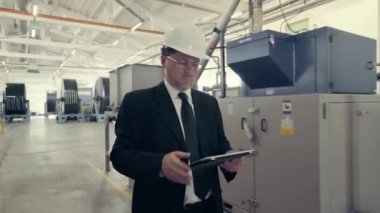 İşadamı baret fabrika ile yürüyüş içinde
