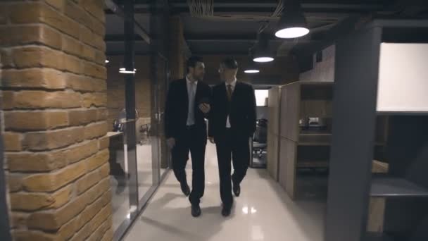 Empresarios caminando por el pasillo y hablando — Vídeo de stock