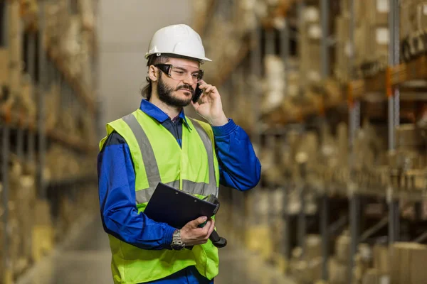 Arbeiter telefoniert im Lager — Stockfoto