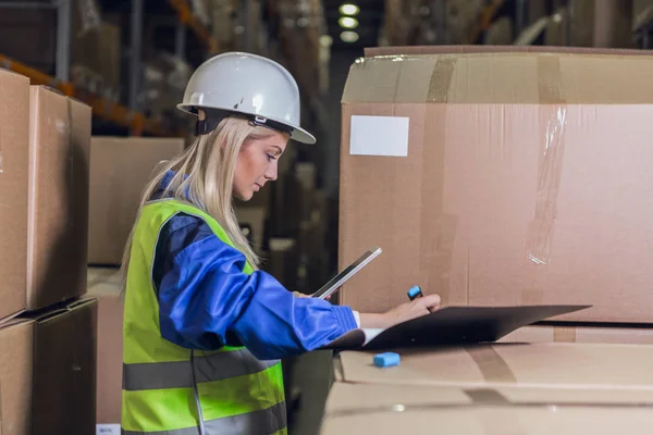 Lagerarbeiterin macht sich Notizen in Dokumenten — Stockfoto