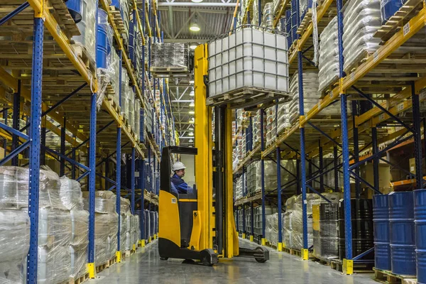 Magazijnmedewerker op stacker nemen van lading van de plank — Stockfoto