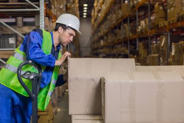 Ambar içinde mal ile kutuları kontrol işçi